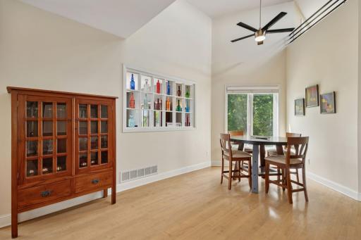 The informal dining room features a vaulted ceiling that brings in light from the transom windows.