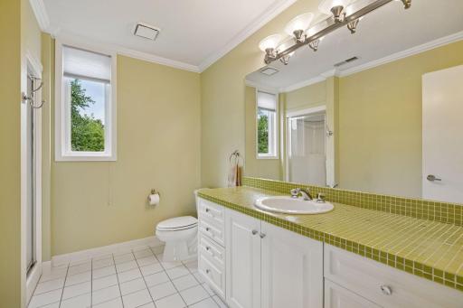 The private ensuite features an enameled vanity and tiled flooring.