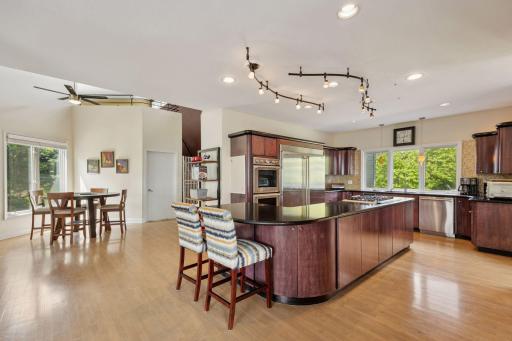 The spacious Kitchen features extensive custom cabinetry, granite countertop and hardwood flooring.