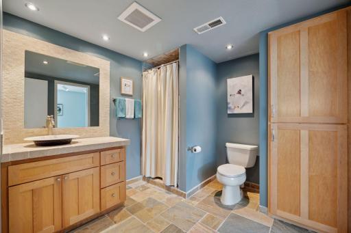 A second 3/4 Bathroom features tiled flooring and custom cabinetry.