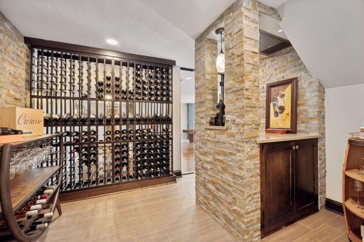 The impressive wine cellar features tiled flooring, custom racking and a tasting counter enclosed by floor-to-ceiling glass walls.