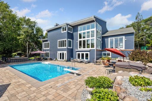 The heated, saltwater pool is surrounded by a paver pool deck and custom landscaping that includes built-in speakers.