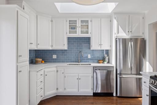 Step into the kitchen featuring sleek stainless steel appliances, beautiful tiling, skylight, and abundant cabinet space