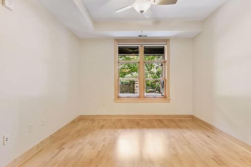 Primary bedroom overlooks back of building patio