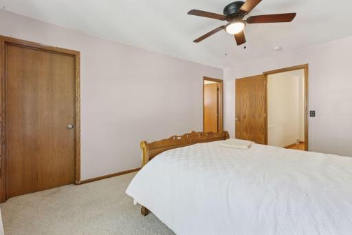 View of primary bedroom closet (door on the left), private full bath (in the middle), and doorway to hallway.