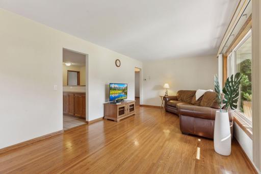 Living room with hardwood floors and natural light from large window.