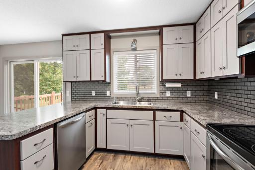 Updated Kitchen with stainless steel appliances, tile backsplash, breakfast bar, pantry cabinet, ceiling fan and Freshly Painted Cabinets