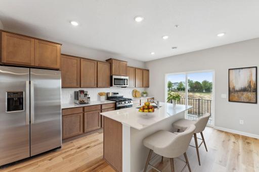 Warm and inviting! The kitchen has timeless finishes that blend an elevated feel with functionality. Similar home shown.