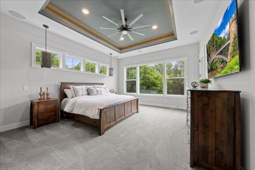Primary Main level Bedroom is huge! It has private access to the deck. This is a true ensuite w/ lounge space, Private Bath, walk-in closet &Laundry room. The lighted tray ceiling is an upgrade creating atmosphere along with sound system