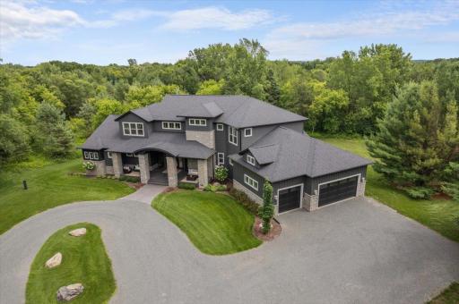 Desirable circular driveway. Attractive blend of warm stone and stately gray tones