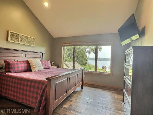 The spacious primary bedroom features vaulted ceilings and a spectacular lake view. Measuring 22 by 14 feet, it offers plenty of room to relax and unwind.