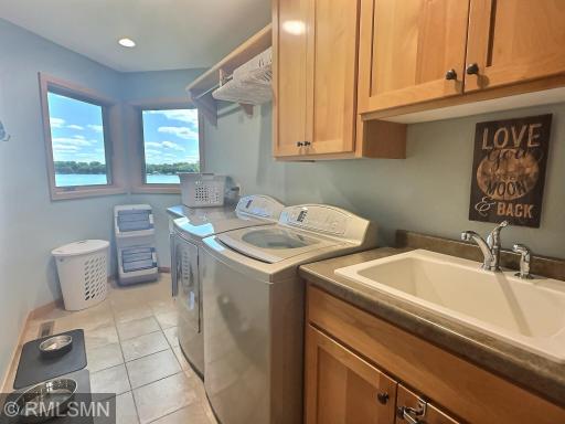 Even the main floor laundry room offers a lovely lake view! It also features a handy laundry sink, linen closets and cabinets, a hanging bar, and a folding table for added convenience.