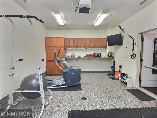 The back of the third stall features built-in cabinets and a countertop, making it ideal for a workshop if desired. A door separates this stall from the others for added functionality.