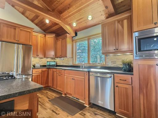 An abundance of custom Douglas fir cabinets grace the kitchen, providing a place for everything. A stylish tile backsplash keeps the space clean and shiny, while natural light flows in through the window above the sink.