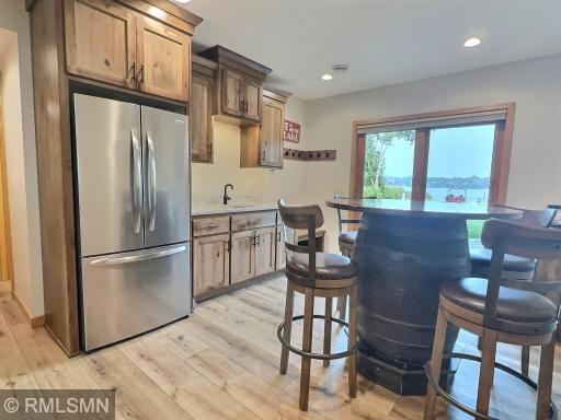 The perfect spot to relax, play games, and enjoy a beverage! This newly installed wet bar features plentiful hickory cabinets, quartz countertops, and a full-size stainless steel refrigeratorâeverything you need for entertaining.