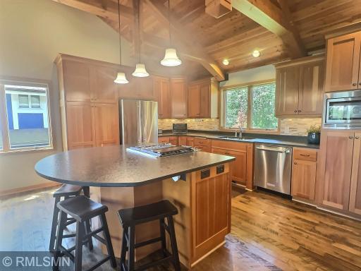 This beautiful countertop-height island features a built-in downdraft gas cooktop and oven, topped with elegant leather-finished dark brown granite.