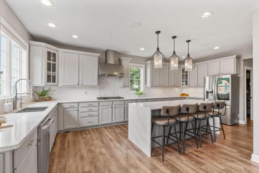 The kitchen features stainless steel appliances that include dual wall ovens, new 5 burner gas cook-top w/ decorative hood, new modern French door refrigerator & dishwasher