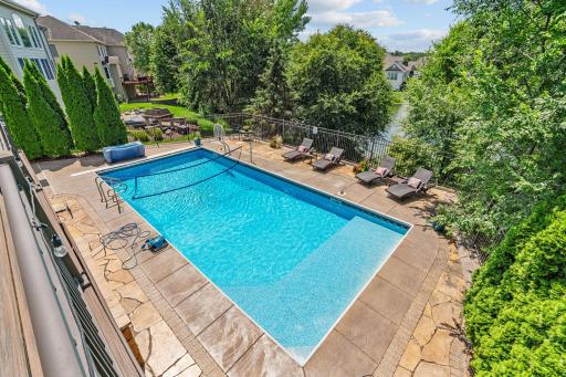 Fenced-in underground saltwater swimming pool and flagstone patio surround
