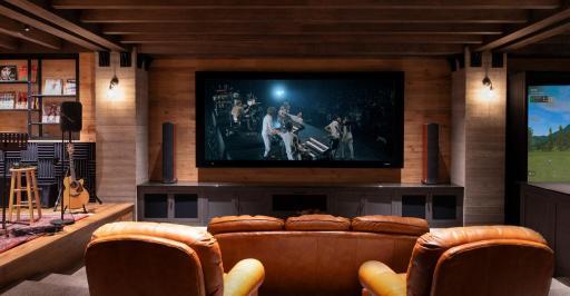 Entertainment reaches a new level here—with a home theater, stage for live performances, and a golf simulator for year-round play. Photo of a theater room designed and built by BCD Homes