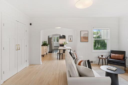 The open living and dining rooms are flooded with natural light and have beautiful hardwood floors