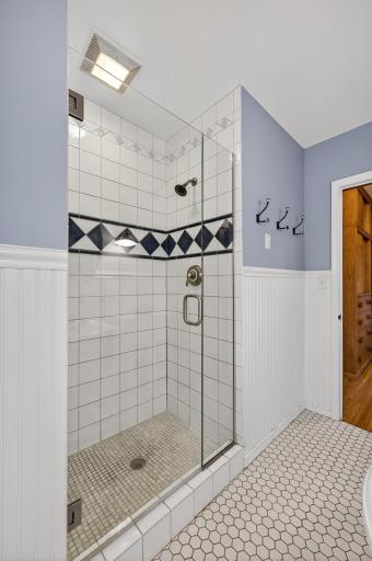 Heavy, beveled glass shower door complete the shower enclosure.