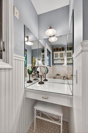 The make-up vanity has mirrors that create lovely reflections of the bathroom accessories.