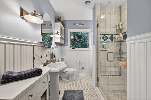 In 2007 the main level bathroom was remodeled in exquisite detail; a shower stall with floor to ceiling ceramic tile, a classic pedestal sink, white enameled wainscot, and heated floors covered by penny round tile.