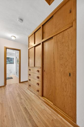 This main level hallway has built-in closets and drawers for handy storage.