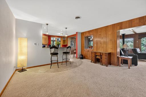 Kitchen breakfast bar has pendant lighting overhead.