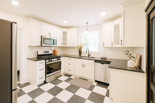 Black and white tiled kitchen with new appliances.