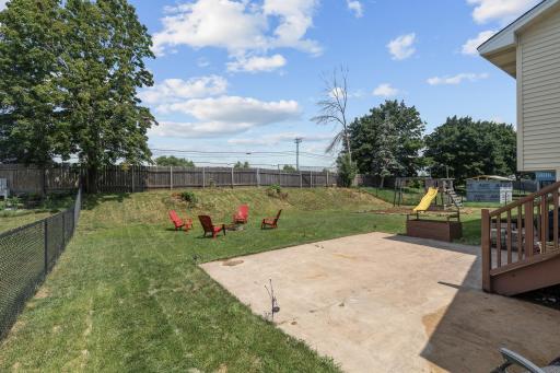Spacious backyard with patio, firepit, and playset