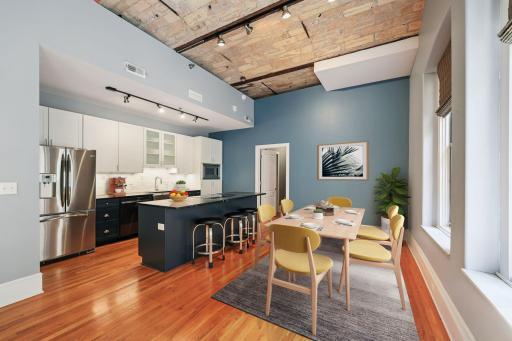 View of the informal Dining Room & Generously sized Kitchen, which has received numerous updates including: New center island, custom lower cabinets, Soap Stone Countertops, & SS appliances (w/ new dishwasher & Range)! (virtually staged image)