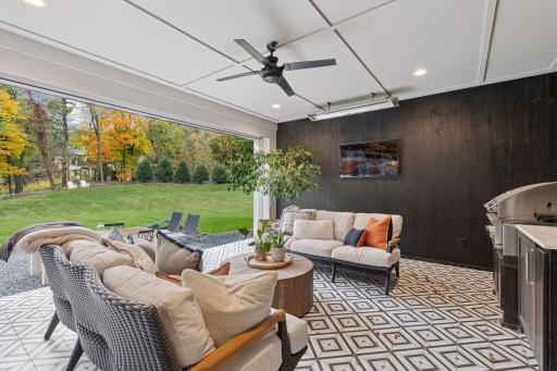 Rear porch with phantom screen, television, grill area, and heater. Over looking the spacious backyard.