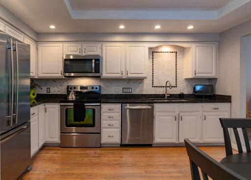 Photo for 11270 36th Place N, Plymouth, MN 55441 - listing #6760580 The spacious kitchen features beautiful tray ceiling with recessed lighting, hardwood flooring, granite countertops, tile backsplash and newer stainless steel appliances.