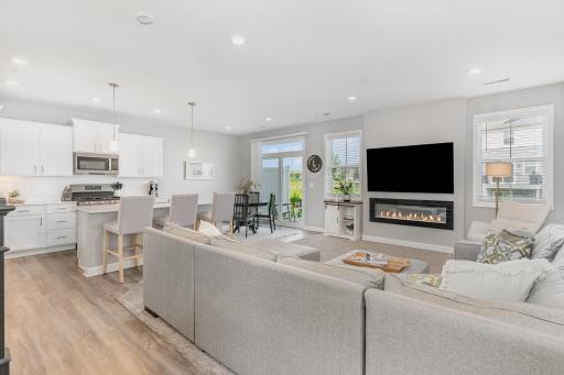 Open concept main level has a modern fireplace. The two double-pane windows and sliding glass door offer so much light.