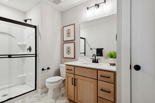 Full lower level bathroom with additional linen storage closet