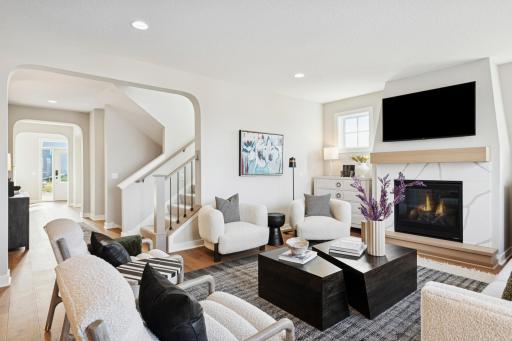 Beautifully tied in stained mantel and hearth with railing and metal balusters on the stairs
