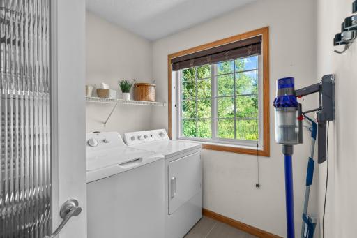 Full size washer and dryer with a large window for natural light and views of wetland while doing laundry