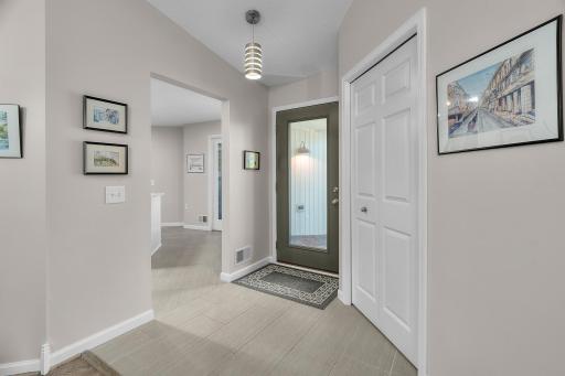 Tiled foyer with large closet and pendant light greet you.