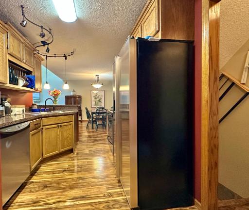 This view looking through the kitchen with the dining in the background. Also this view reveals the stairs to the unfinished lower level and all the storage you need.