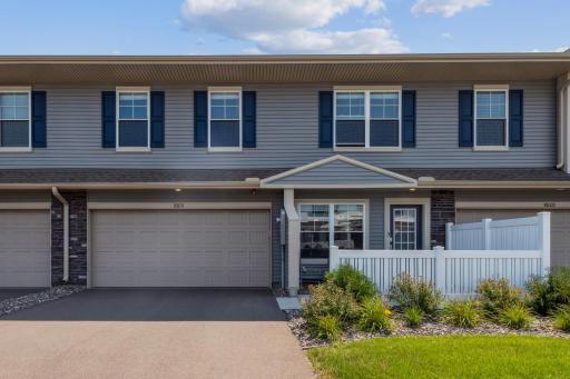 Beautiful and well-maintained townhome exterior featuring modern gray siding, charming blue shutters, and a spacious two-car garage.