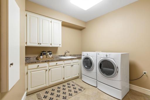 Main level laundry room with storage and sink makes this chore a breeze!
