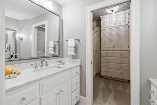 Primary ensuite with multiple vanities, separate tub and walk-in shower and walk-in closet with custom closet insert.