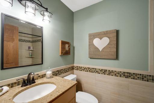 The main bathroom on the upper level also features newer tile in bathroom and tub surround, fixtures and lighting.