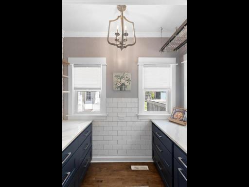 The quartz counters continue into the pantry and sleek subway tile line the walls