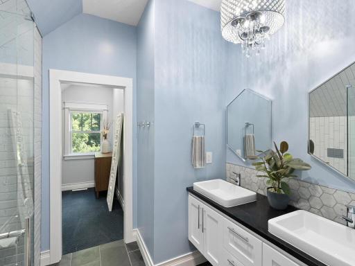 Spa-like master bathroom includes a dual vanity, walk-in shower, and leads into the walk-in closet