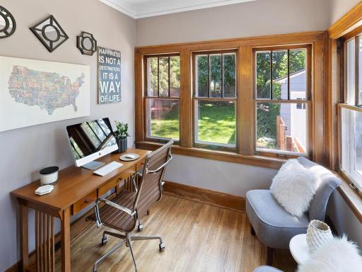 The hardwood floors and natural light continue into the main level office space.