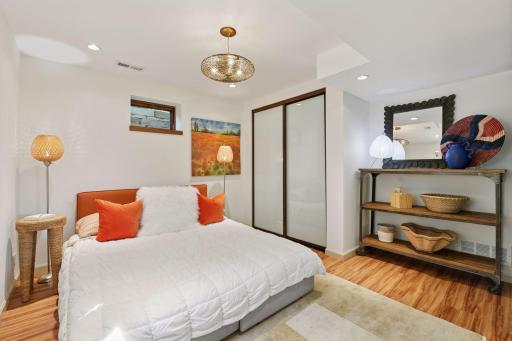 Private lower-level bedroom with custom glass doors offering a stylish transition to the family room