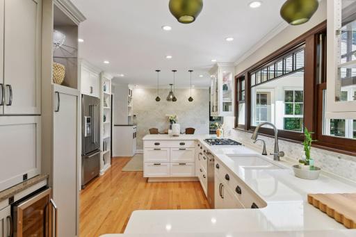 The modern kitchen features sleek quartz countertops, appliance garage, and wine cooler