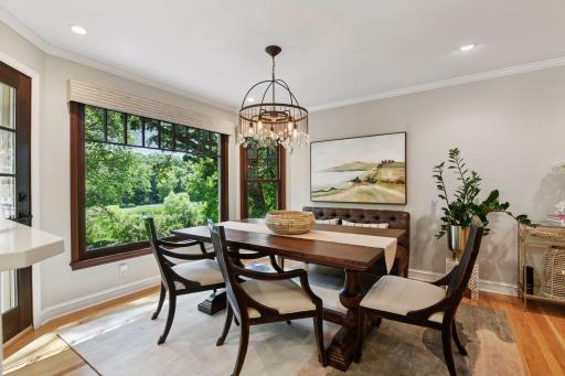 Enjoy meals beneath a striking chandelier in the informal dining room, where a large picture window offers sweeping views of the lush backyard